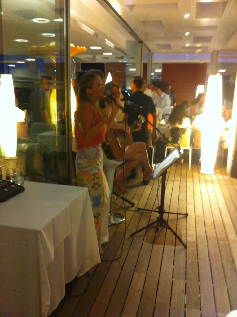Live music performance at an event in Malaga featuring a singer with a professional microphone and a guitarist, creating a vibrant and elegant atmosphere.