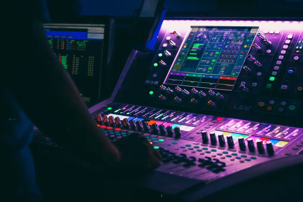 A close-up of a modern sound system control panel with colorful knobs, buttons, and a digital interface.