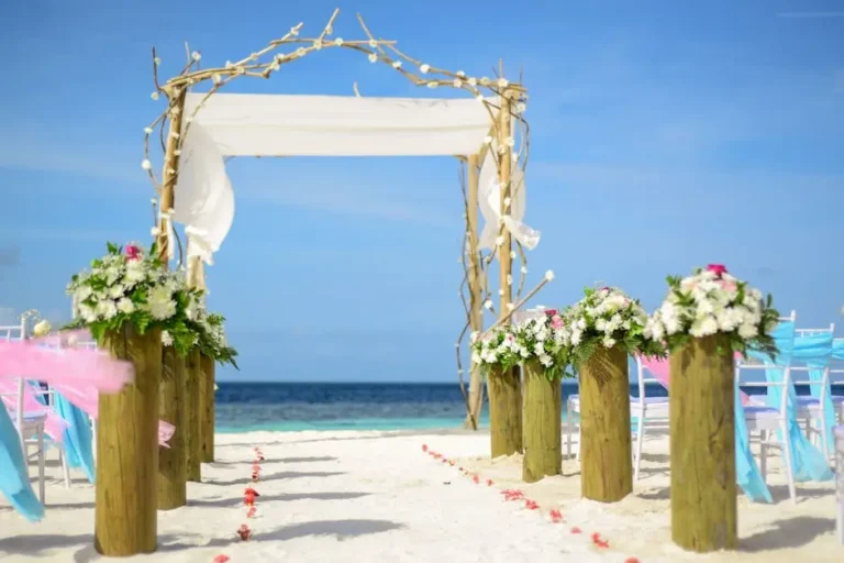 A beautiful beach wedding ceremony setup with an arch and flowers.