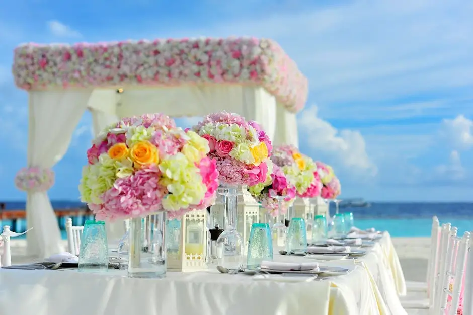 Elegant wedding table setup with floral centerpieces by the beach.