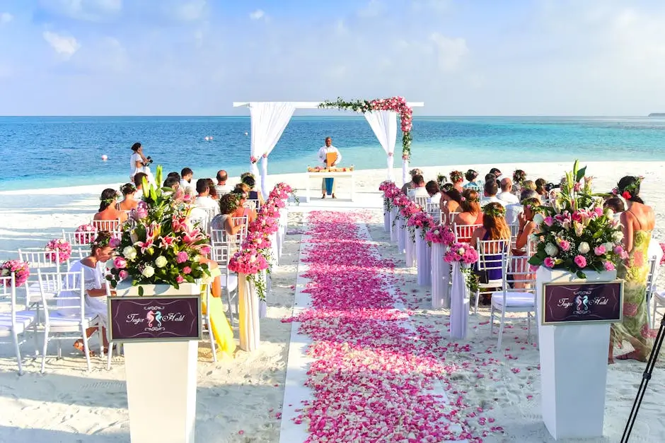A vibrant tropical beach wedding ceremony with pink rose petals and ocean views.