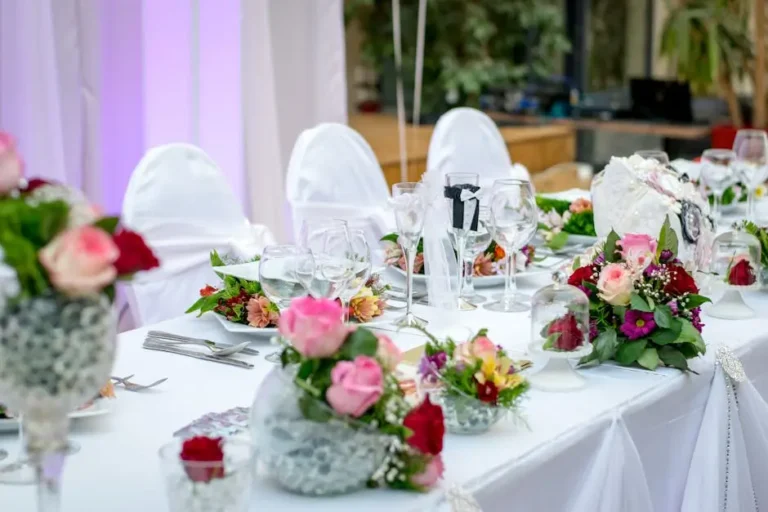 Elegant wedding table setting with floral centerpieces and white linens.