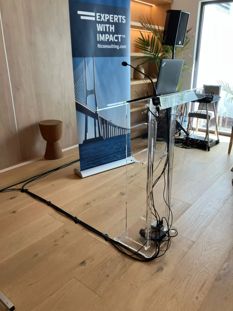 A professional FTI Consulting corporate presentation setup featuring a podium with a microphone and laptop, FTI Consulting.