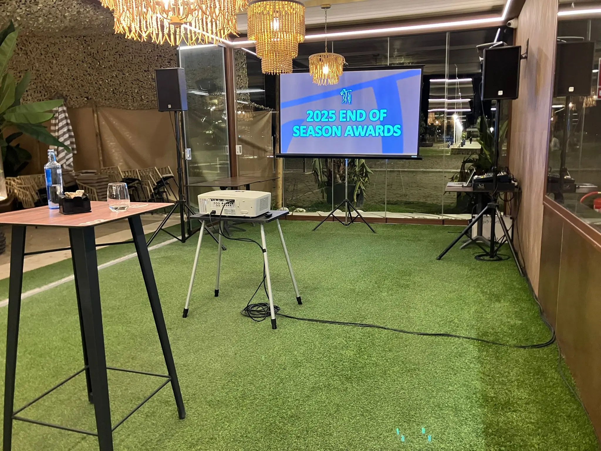 Indoor event setup with a projector screen and professional sound equipment for audio video rental in malaga.